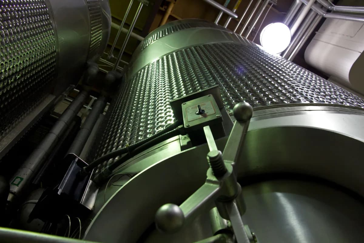 Large stainless-steel process vessels and pipework inside an industrial plant