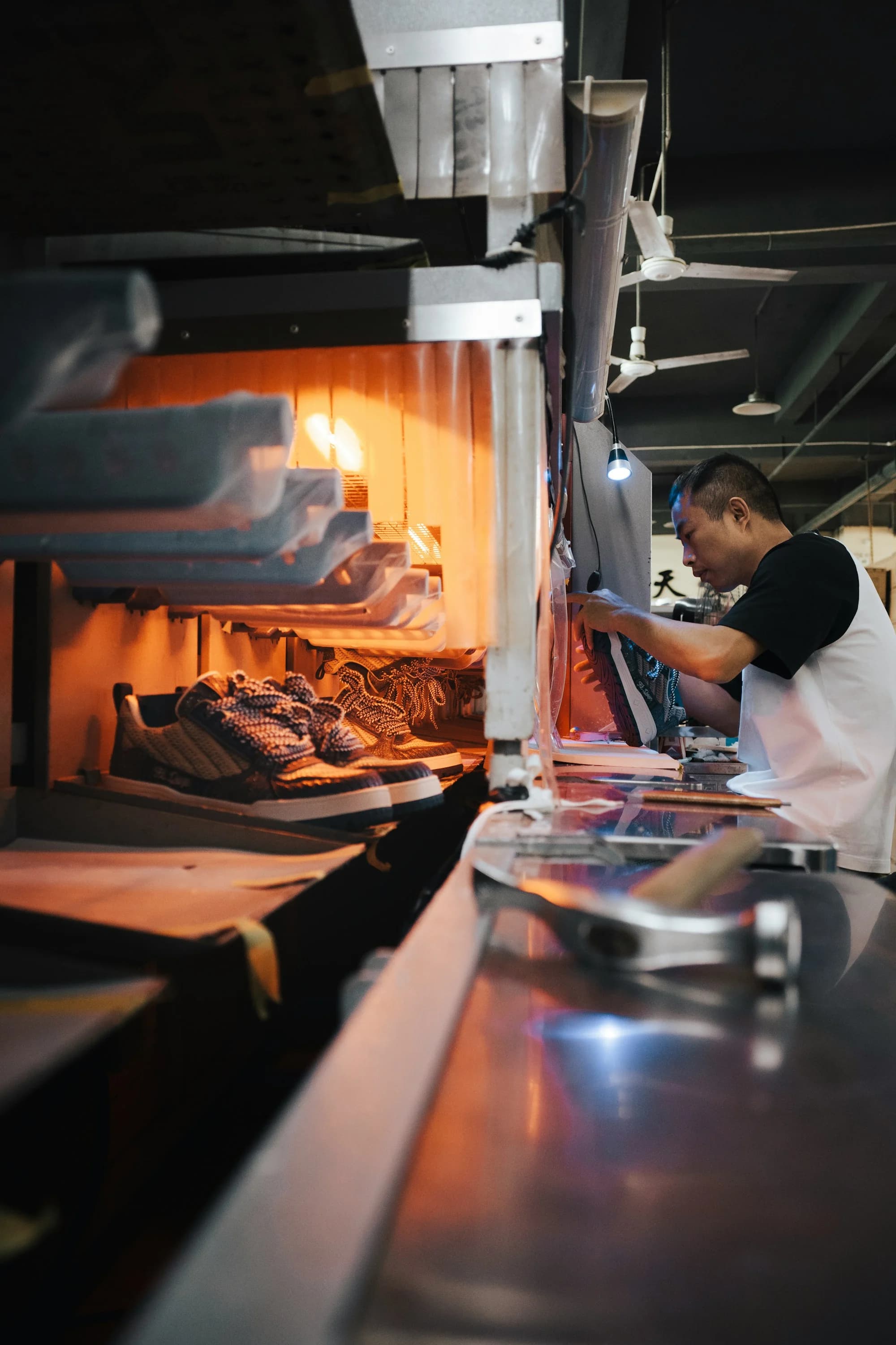 Footwear worker operating an industrial shoe production station