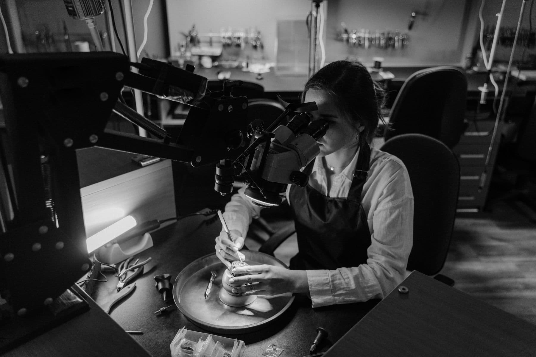 Jewellery professional using a microscope at a precision setting bench