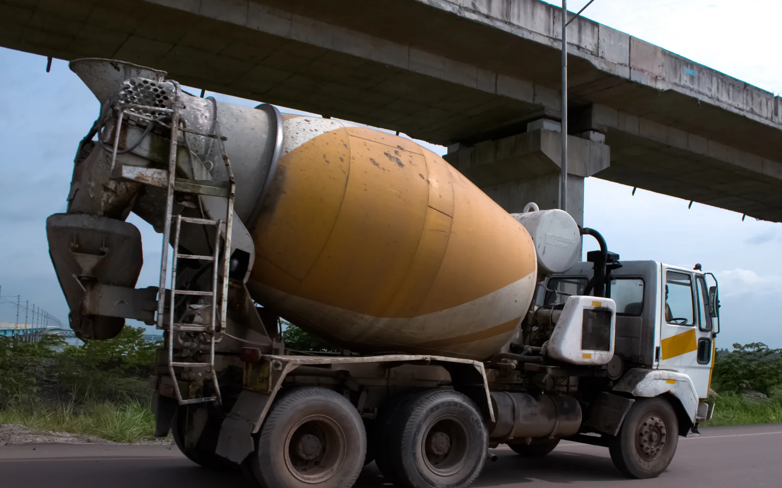 Concrete mixer truck travelling beneath an overpass in Kochi, Kerala