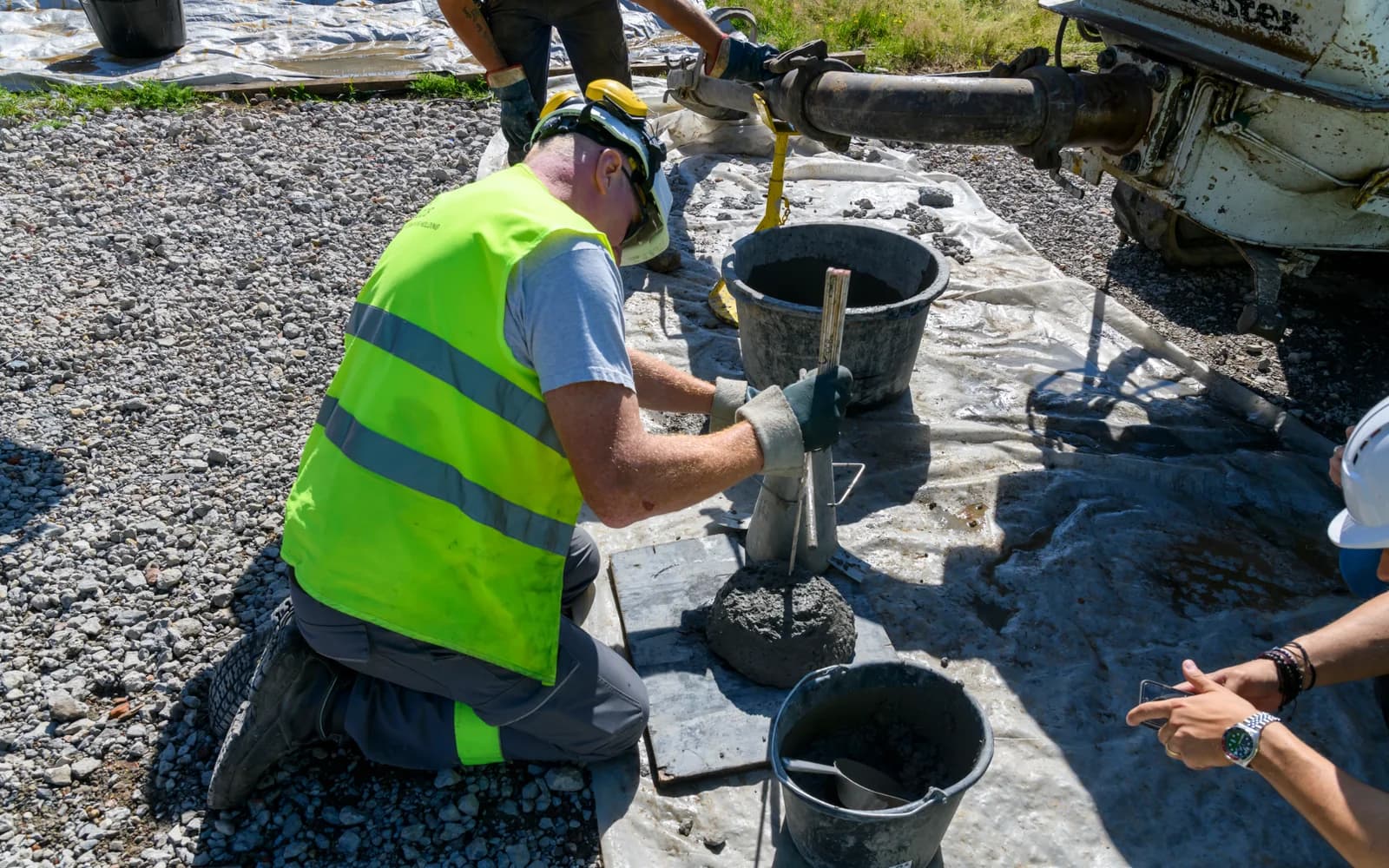 Construction worker performing a field slump test on fresh concrete